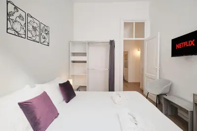 a bedroom with a large white bed with purple pillows at Vatican Museums - Modern flat with Wi-Fi & Netflix in Rome