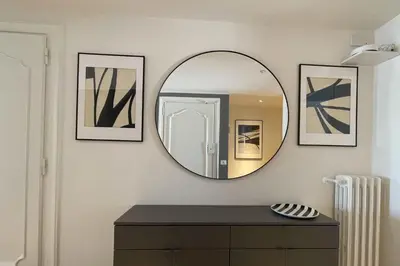a mirror on a wall with two pictures and a dresser at Appartamento al Vaticano in Rome