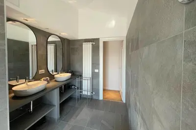 a bathroom with two sinks and two mirrors at Appartamento al Vaticano in Rome