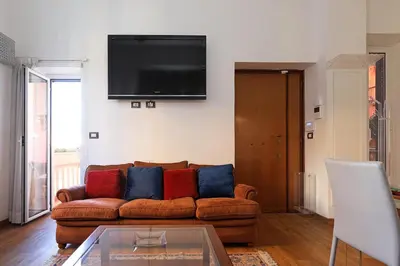 a living room with a couch and a tv on a wall at Stella House in Rome