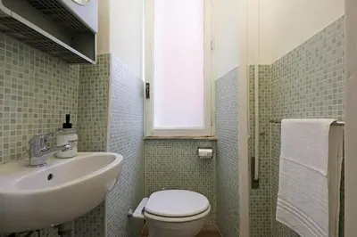 a bathroom with a sink and a toilet and a window at Bologna GARDEN HOUSE in Rome