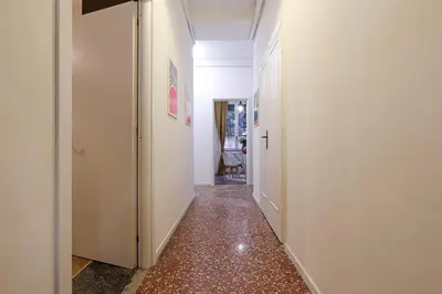 a hallway with white walls and red tile floors at Bologna GARDEN HOUSE in Rome