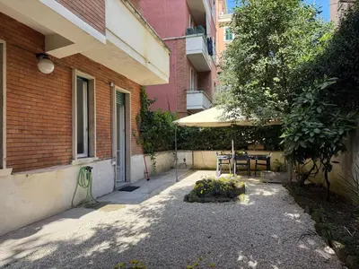 a patio with a table and an umbrella next to a building at Bologna GARDEN HOUSE in Rome