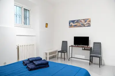 a bedroom with a bed and a desk and a tv at Lion Renting Vatican Apartment in Rome