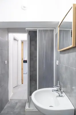 a bathroom with a white sink and a mirror at Lion Renting Vatican Apartment in Rome