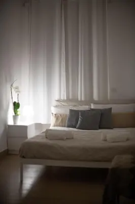a white bedroom with a large bed with a window at BFabretti5 in Rome