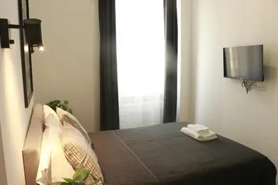 a bedroom with a bed with a television on the wall at Giulio Cesare Comfort Rooms in Rome