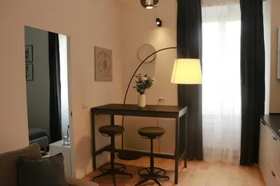 a room with a table with two stools and a lamp at Giulio Cesare Comfort Rooms in Rome