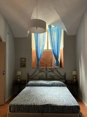 a bedroom with a large bed with blue curtains at Luminosa e accogliente casa Centro Storico in Rome