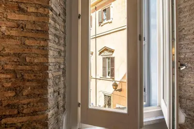 a room with a window and a brick wall at Exclusive House Ghetto in Rome