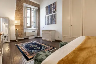 a bedroom with a bed and a dresser and a window at Exclusive House Ghetto in Rome