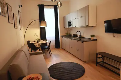 a living room with a couch and a kitchen with a table at Giulio Cesare - Casa Palmeri in Rome