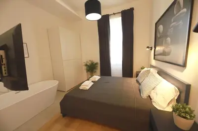 a bedroom with a bed and a tub and a television at Giulio Cesare - Casa Palmeri in Rome