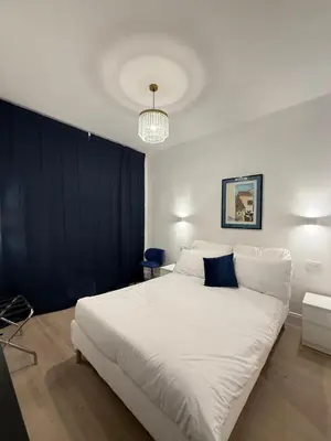 a bedroom with a large white bed with blue pillows at Vita Lux Vatican Suites in Rome
