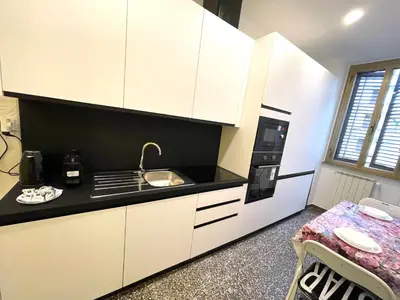 a kitchen with white cabinets and a sink and a stove at Royal Golden House in Rome
