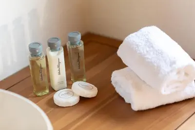 a table with three bottles of soap and a towel at Casa Maestro, a Burghesius home in Rome