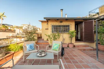 a patio with two chairs and a table on a balcony at Casa Maestro, a Burghesius home in Rome