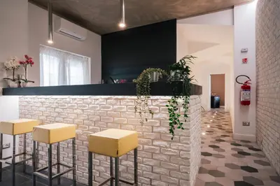 a bar with yellow stools and a brick wall at SuiteFrattini degli Eroi in Rome