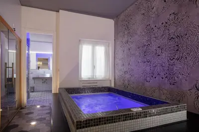 a large bathroom with a large blue tub at SuiteFrattini degli Eroi in Rome