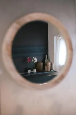 a mirror with flowers on a shelf in a room at SuiteFrattini degli Eroi in Rome
