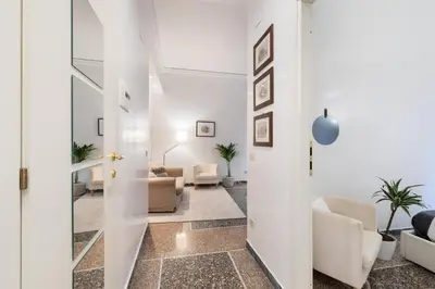 a hallway with a living room with white walls at Kenzia Suite Aventino in Rome