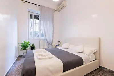 a white bedroom with a large bed with white pillows at Kenzia Suite Aventino in Rome