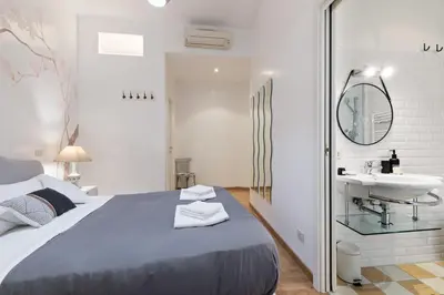a white bedroom with a bed and a sink at Kenzia Suite Aventino in Rome