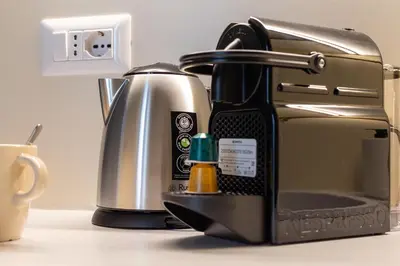 a coffee maker sitting on a counter next to a cup at iFlat Stylish & Cozy apt in the Heart of Monti in Rome