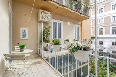 a balcony with potted plants and a table and chairs at iFlat Stylish & Cozy apt in the Heart of Monti in Rome
