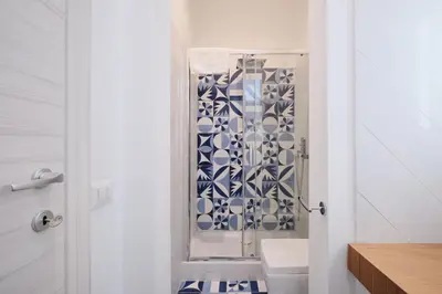 a bathroom with a shower with blue and white tiles at Castel Sant'Angelo - Elegant flat in Rome Centre in Rome
