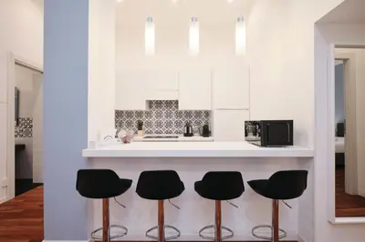 a kitchen with black stools in front of a counter at Castel Sant'Angelo - Elegant flat in Rome Centre in Rome