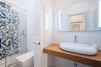 a white bathroom with a sink and a mirror at Castel Sant'Angelo - Elegant flat in Rome Centre in Rome