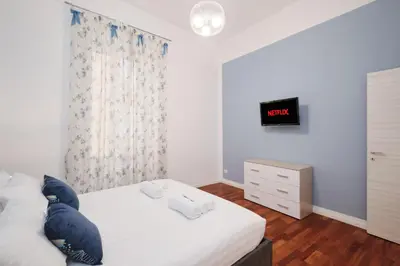 a bedroom with a bed and a dresser with a clock on the wall at Castel Sant'Angelo - Elegant flat in Rome Centre in Rome