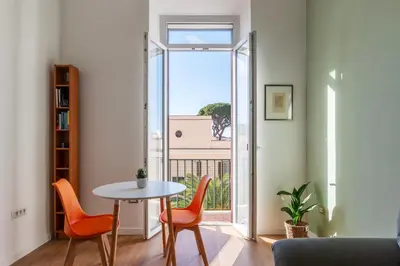 a living room with a table and chairs and a window at GuestHost - Roma San Lorenzo Apartment in Rome