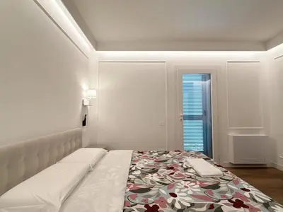 a white bedroom with a bed and a window at Villa Angela in Rome