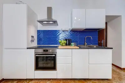 a kitchen with white cabinets and a sink at BDC - Galatea Art Gallery 3BDR at Testaccio in Rome