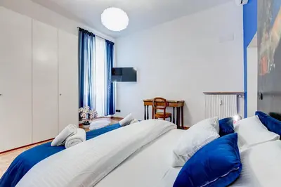a bedroom with two large beds with blue pillows at BDC - Galatea Art Gallery 3BDR at Testaccio in Rome