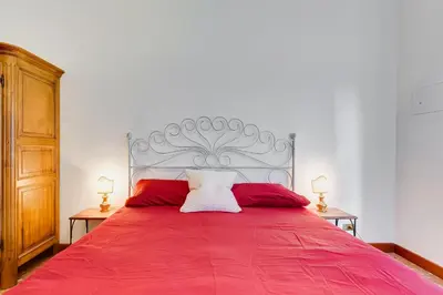 a bedroom with a red bed with two red pillows at Rossini Home in Rome