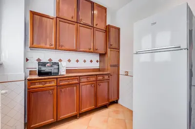 a kitchen with wooden cabinets and a refrigerator at Rossini Home in Rome