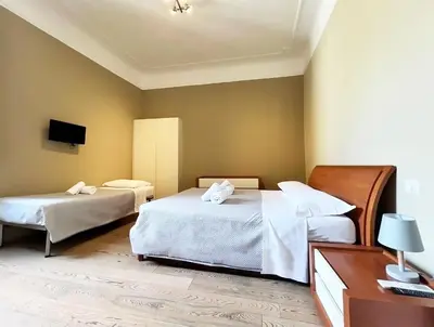 a hotel room with two beds and a tv at La Casa Di Piero in Via Ottaviano in Rome