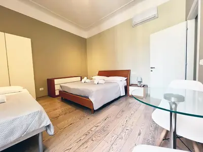 a bedroom with two beds and a glass table at La Casa Di Piero in Via Ottaviano in Rome
