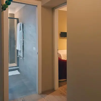 a bathroom with a glass door leading to a bedroom at La Casa Di Piero in Via Ottaviano in Rome