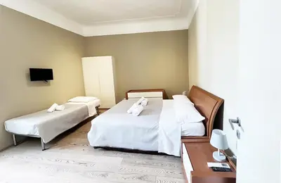 a hotel room with two beds and a tv at La Casa Di Piero in Via Ottaviano in Rome