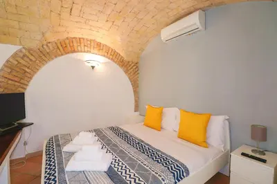 a bedroom with a bed with yellow pillows at Authentic Central Roman Home - Metro 7min, 5min to Rome Center, AC, Wi-Fi in Rome