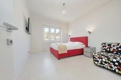 a white bedroom with a bed and a couch at 4BNB - Jacuzzi Trionfale Apartment in Rome