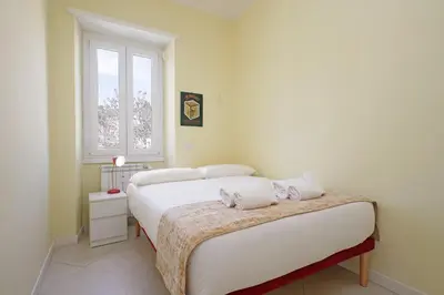 a white bedroom with a red bed and a tv at 4BNB - Jacuzzi Trionfale Apartment in Rome