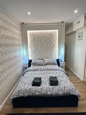 a bedroom with a large bed with two green towels on it at laurus's house in Rome