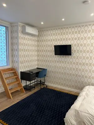 a bedroom with a desk and a television on a wall at laurus's house in Rome