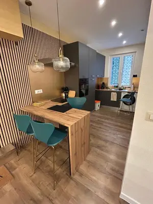 a kitchen with a wooden table and blue chairs at laurus's house in Rome