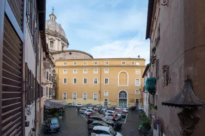 a street with cars parked in front of a building at Pallaro 6 Apartment in Rome